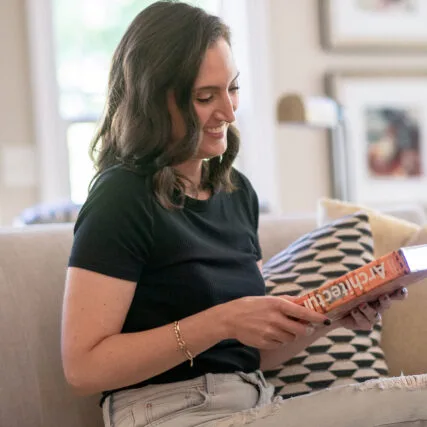 Marissa owner of Reflections Interior Design looking at a coffee table book