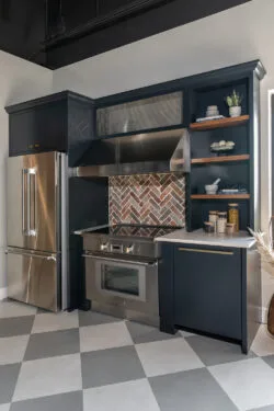 Kitchen with navy cabinets and brick backsplash