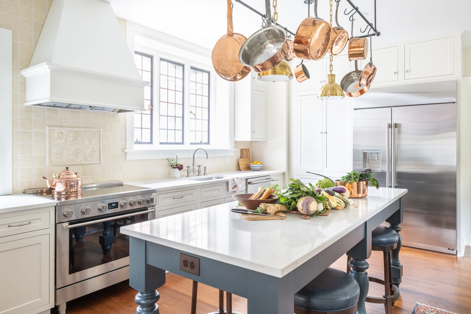 open kitchen space with center island and copper pots hanging from above
