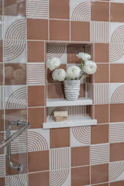 image of coral modern tile in shower with playful floral arrangement in the shower niche