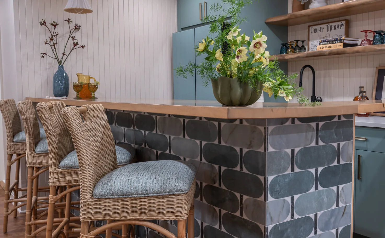 basement bar with blue patterned tiles and woven bar stools