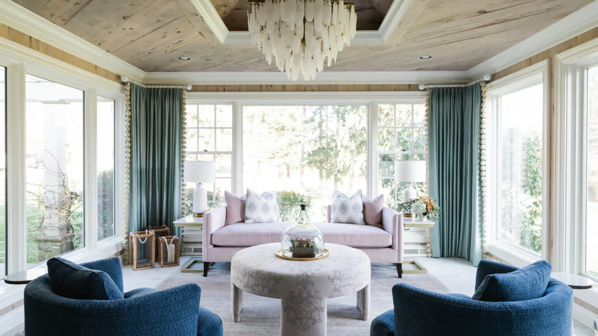 sunroom with wood paneled ceilings, a large chandelier and colorful furniture