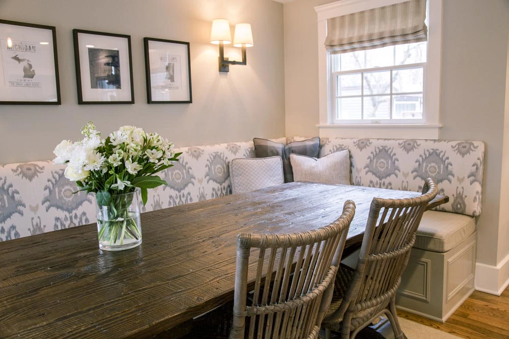 Dining room with a banquet and chairs arranged around a stained table