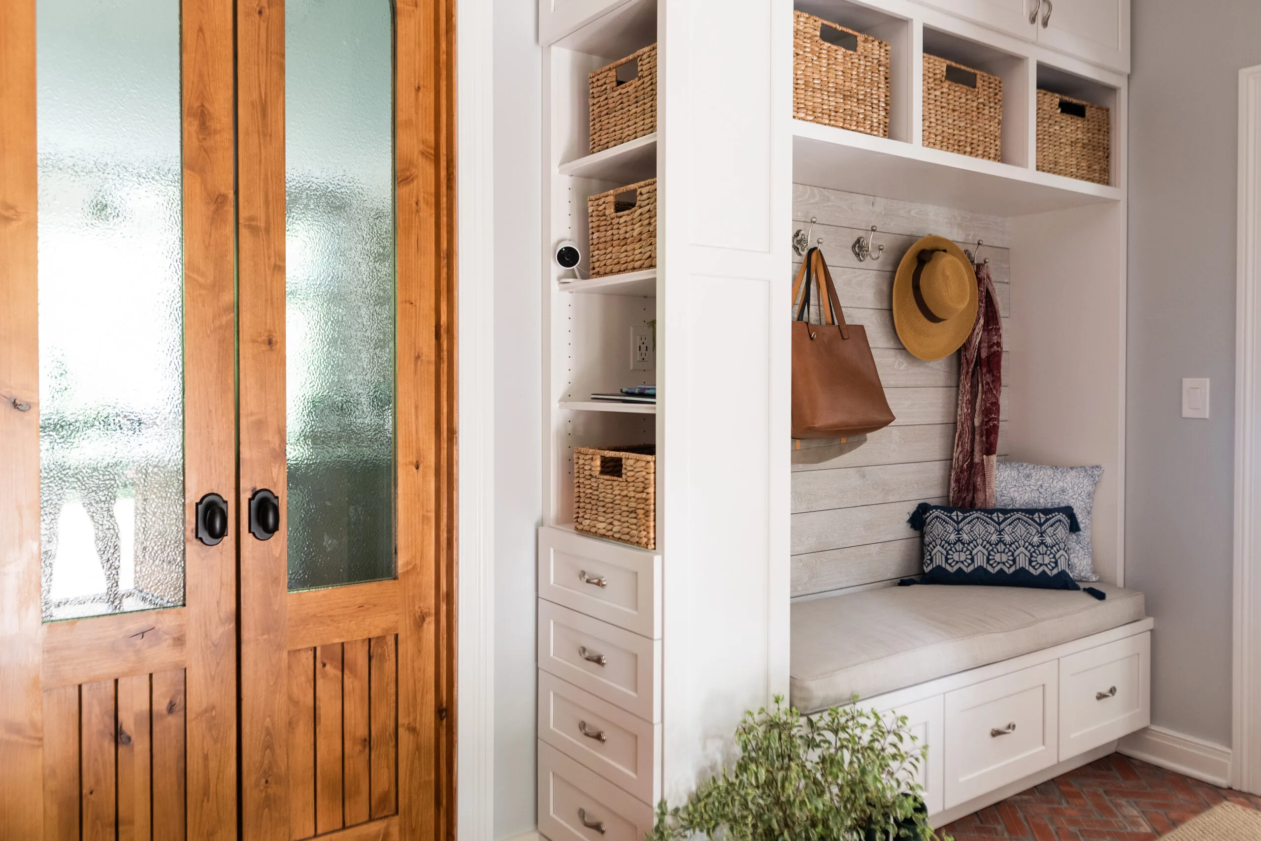 Mudroom with custom built ins with a bench and charging stationand alder wood french doors to kitchen