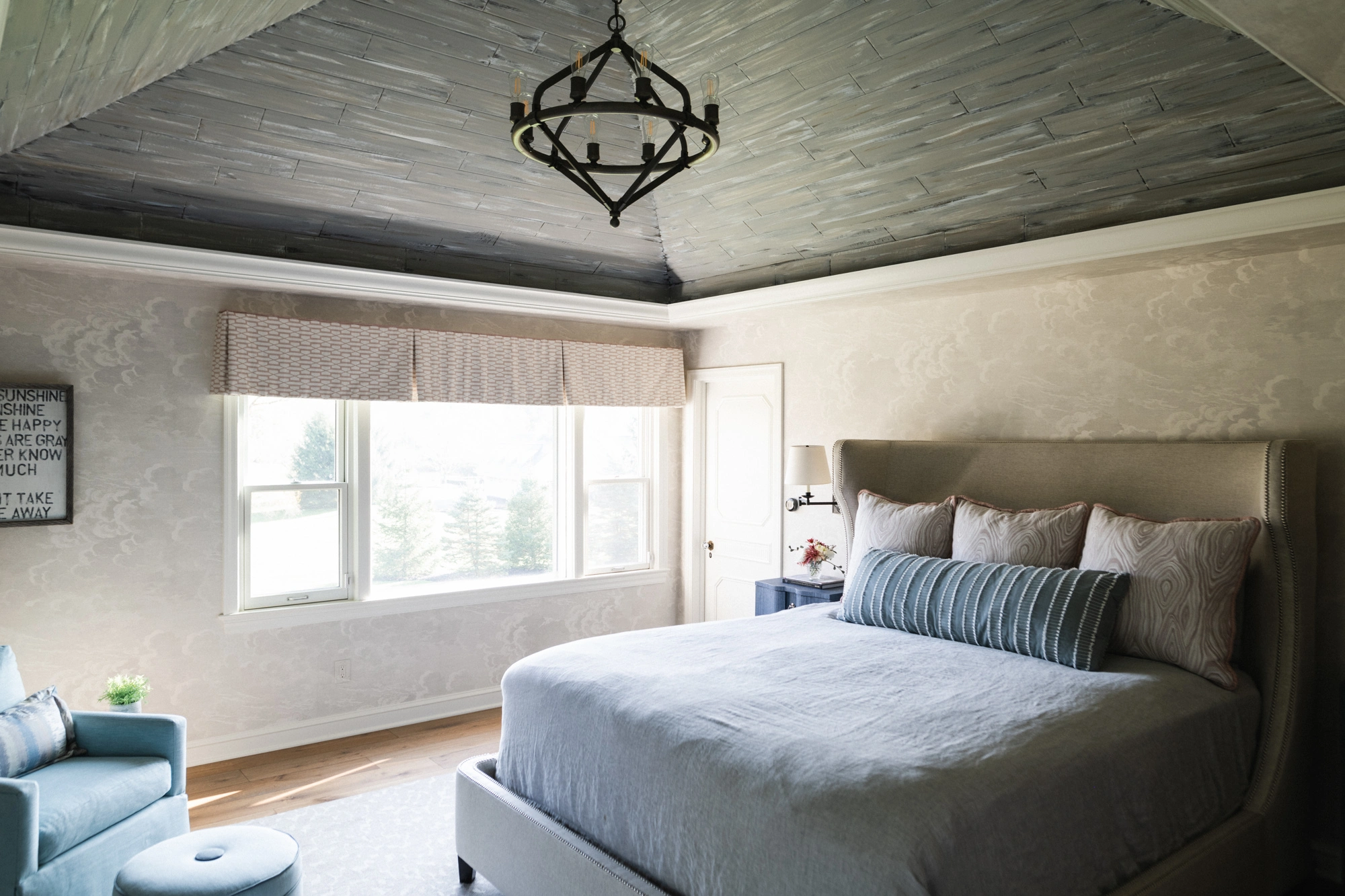 bedroom design with black hanging chandelier over bed
