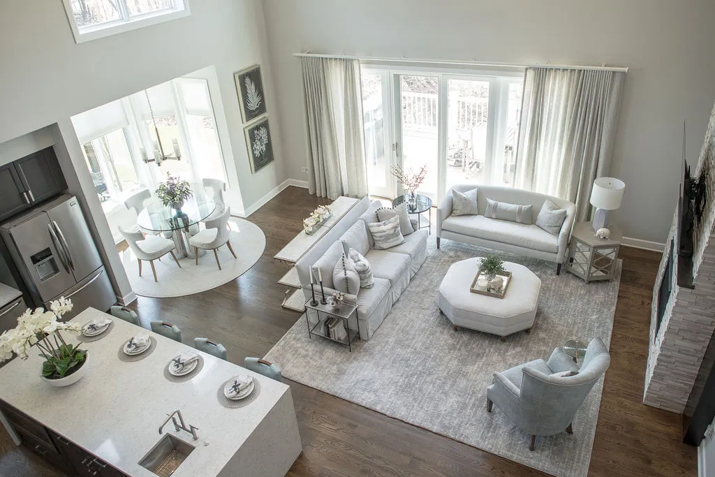 Image of a dining nook, living room, and kitchen with bright, neutral colors taken from above
