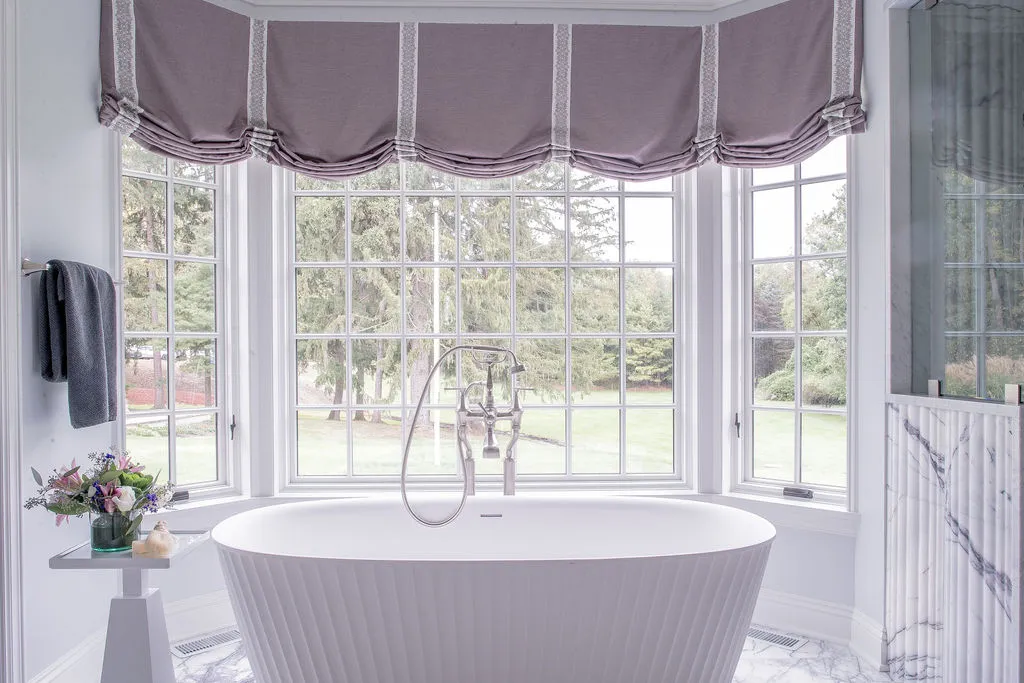 Large soaking tub with an outside view and purple drapery