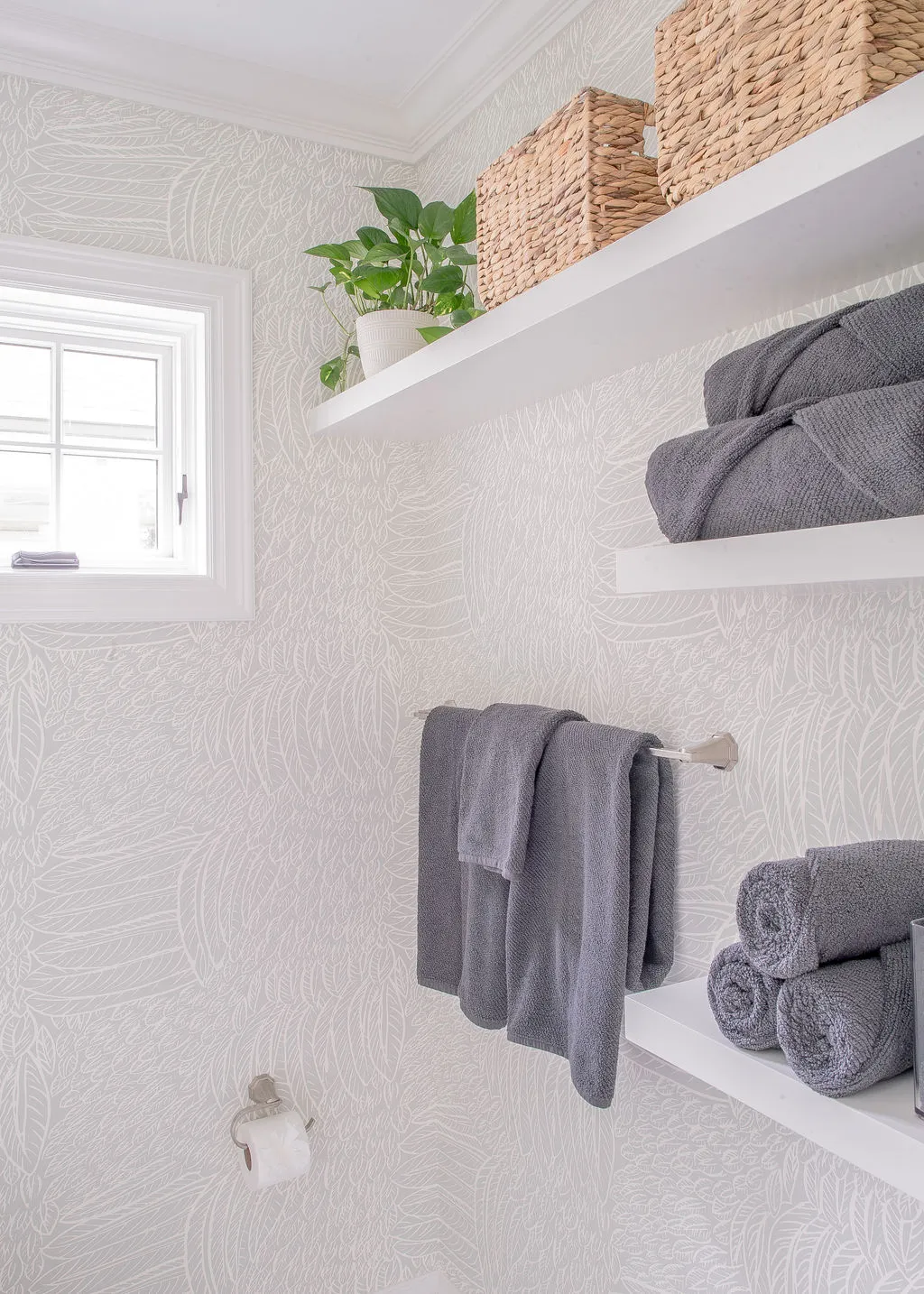 Powder room area with gray towels and greenery