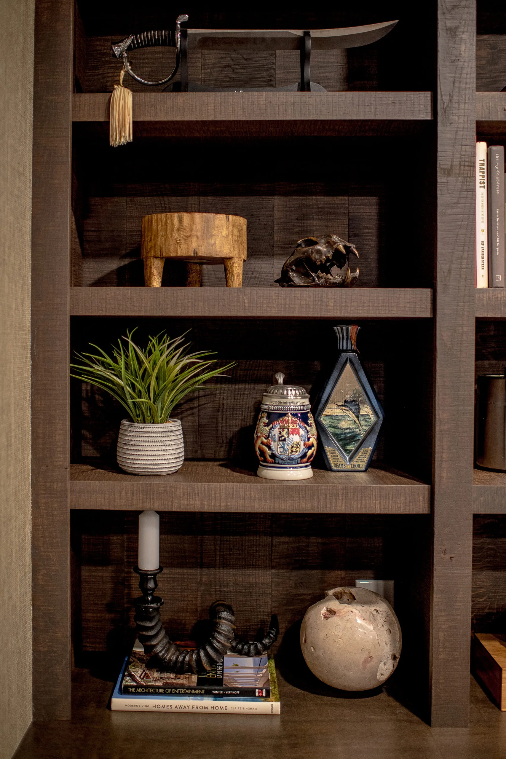 Close up image of dark, stained open shelving with a variety of accessories on each shelf