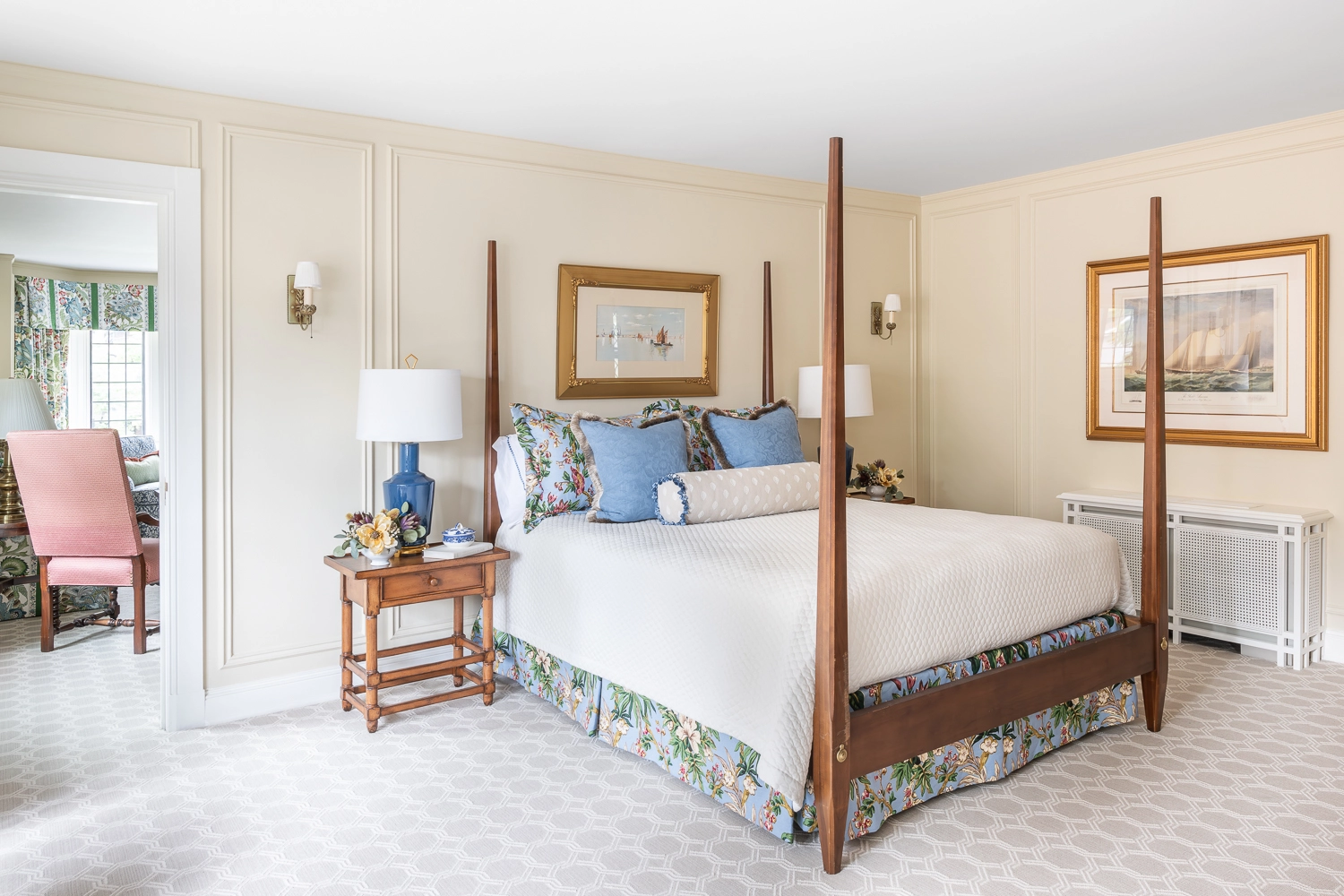 Wooden post bed with artwork above and nightstands with blue lamps on either side
