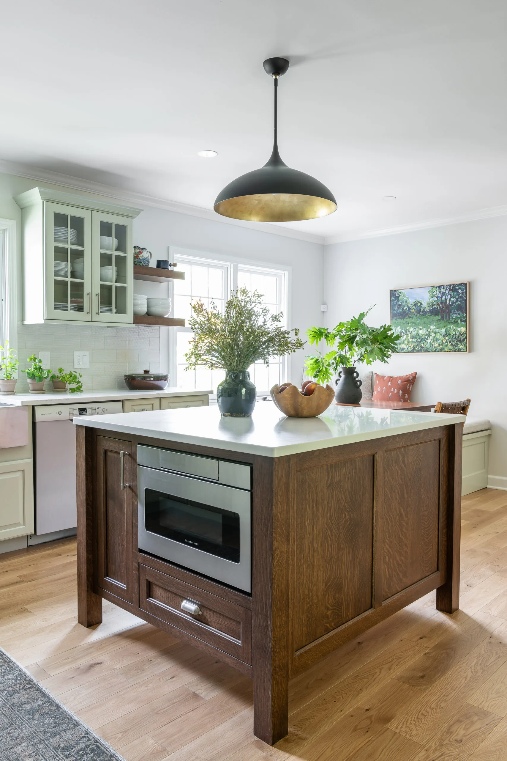 Craftsman style island in cozy kitchen with modern pendant and patterned rug