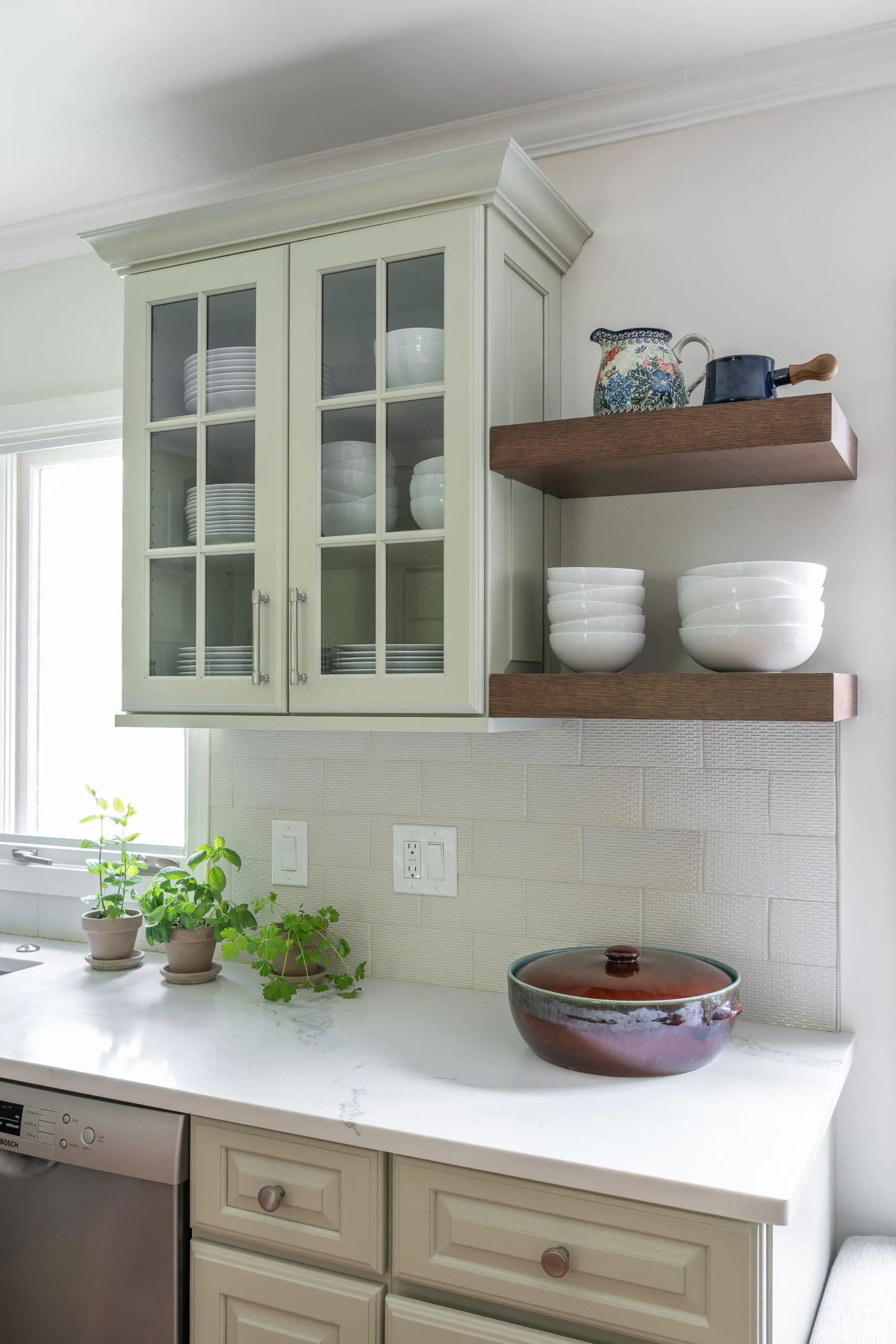 cozy kitchen with glass front cabinetry and white dishware and floating stained shelves for accessories