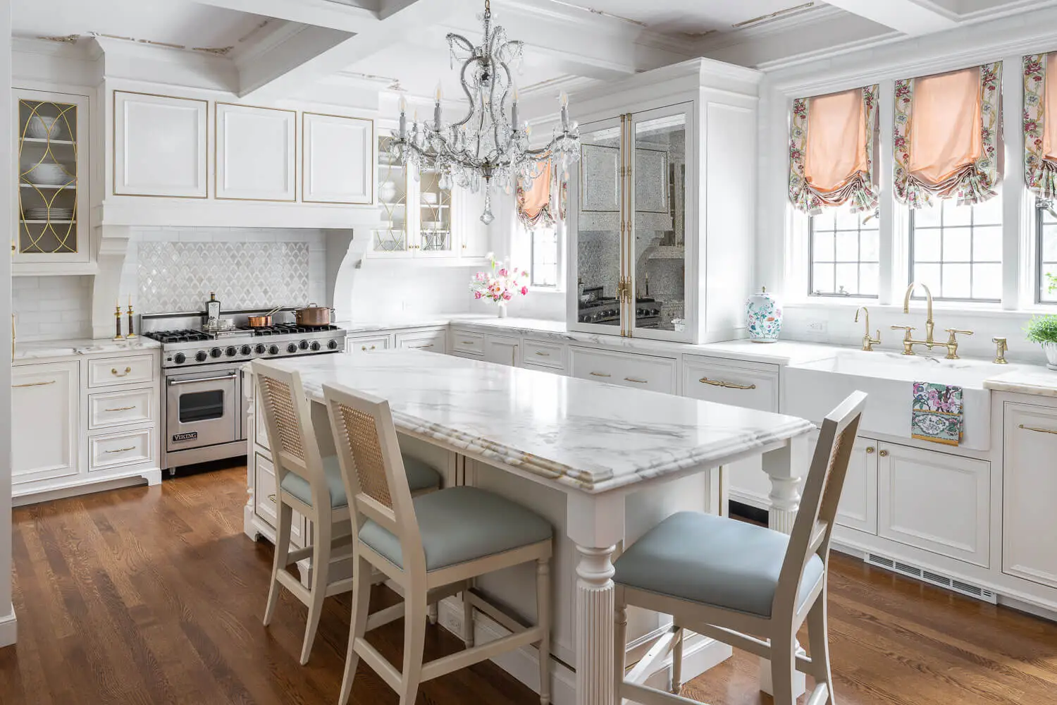 antique chandelier over white marbletop kitchen island