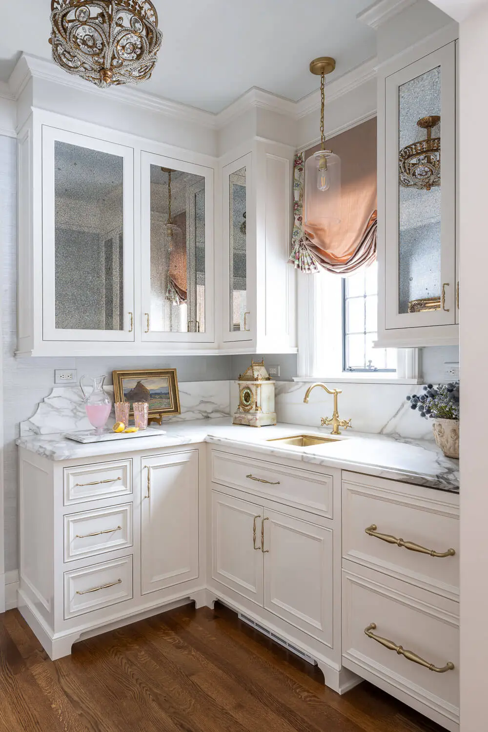 butler's pantry with white cabinetry, marble counters, blue walls, and pink roman shades