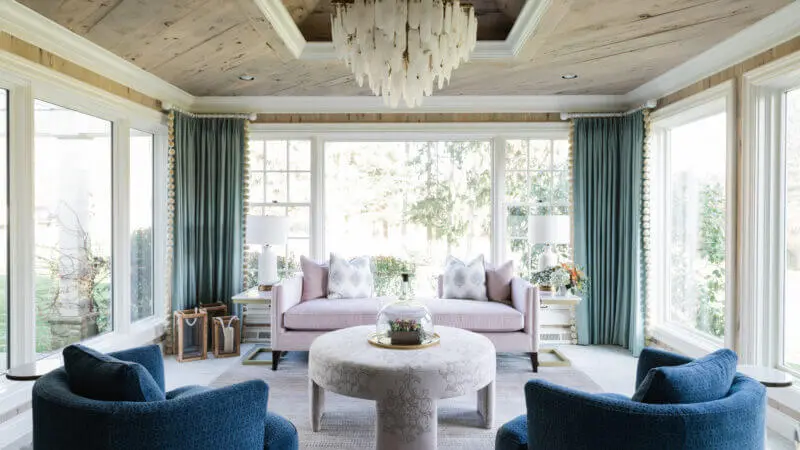 sunroom with wood paneled ceilings, a large chandelier and colorful furniture