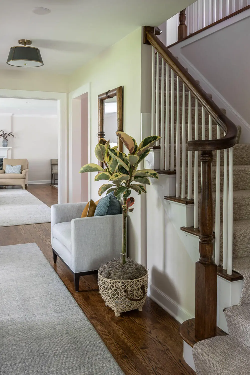 traditional foyer with new railing, modern furnishings and lighting