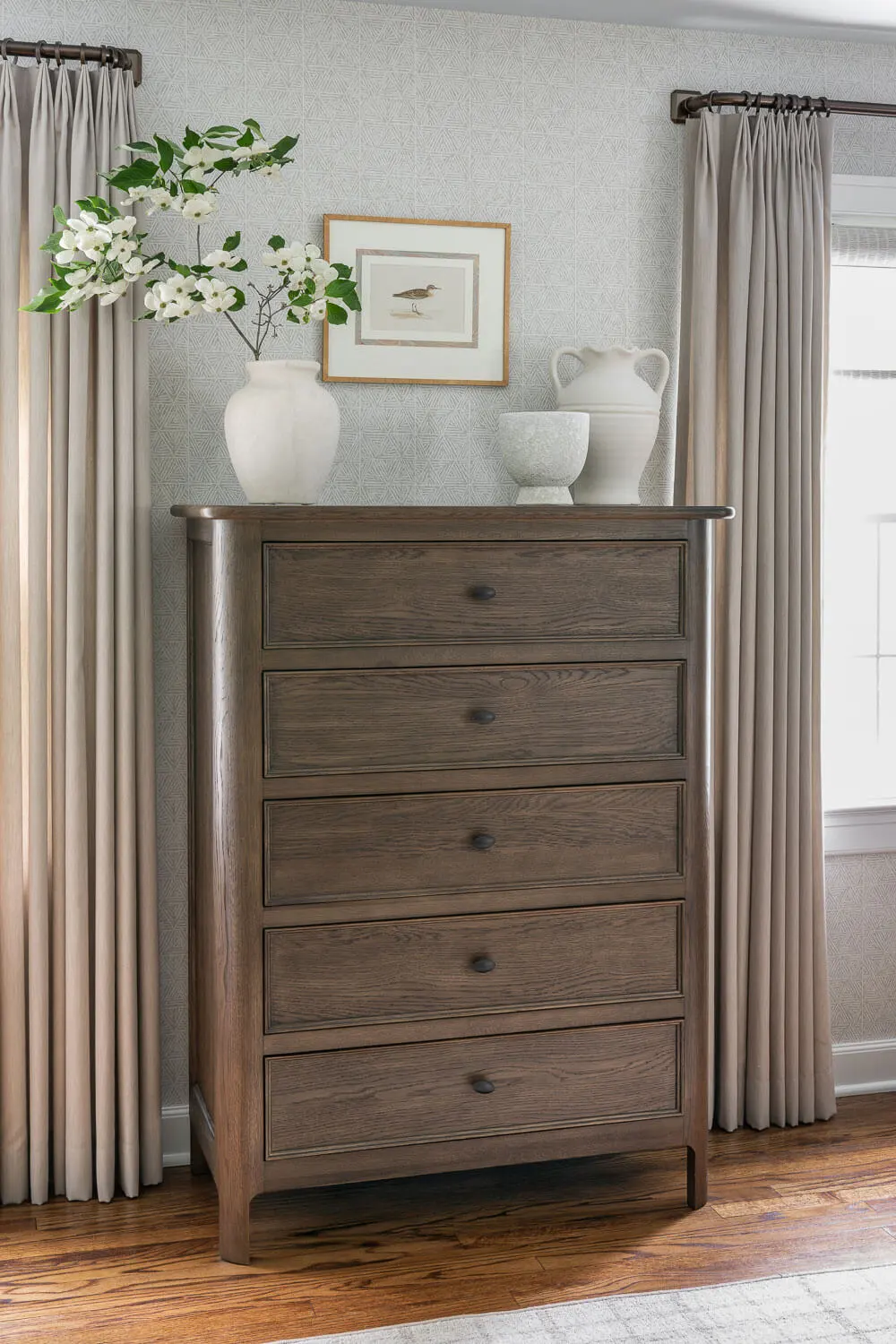 primary bedroom with grasscloth wallpaper and functional and beautiful chest of drawers