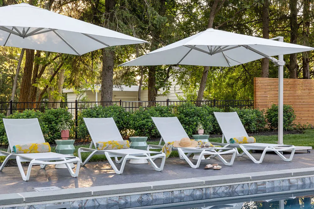 white lounge chairs by a pool