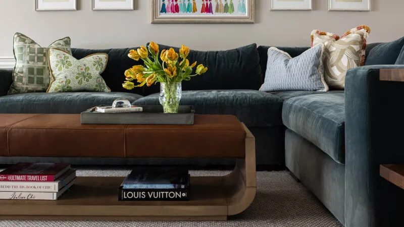 dark blue velvet sectional sofa in a colorful family room