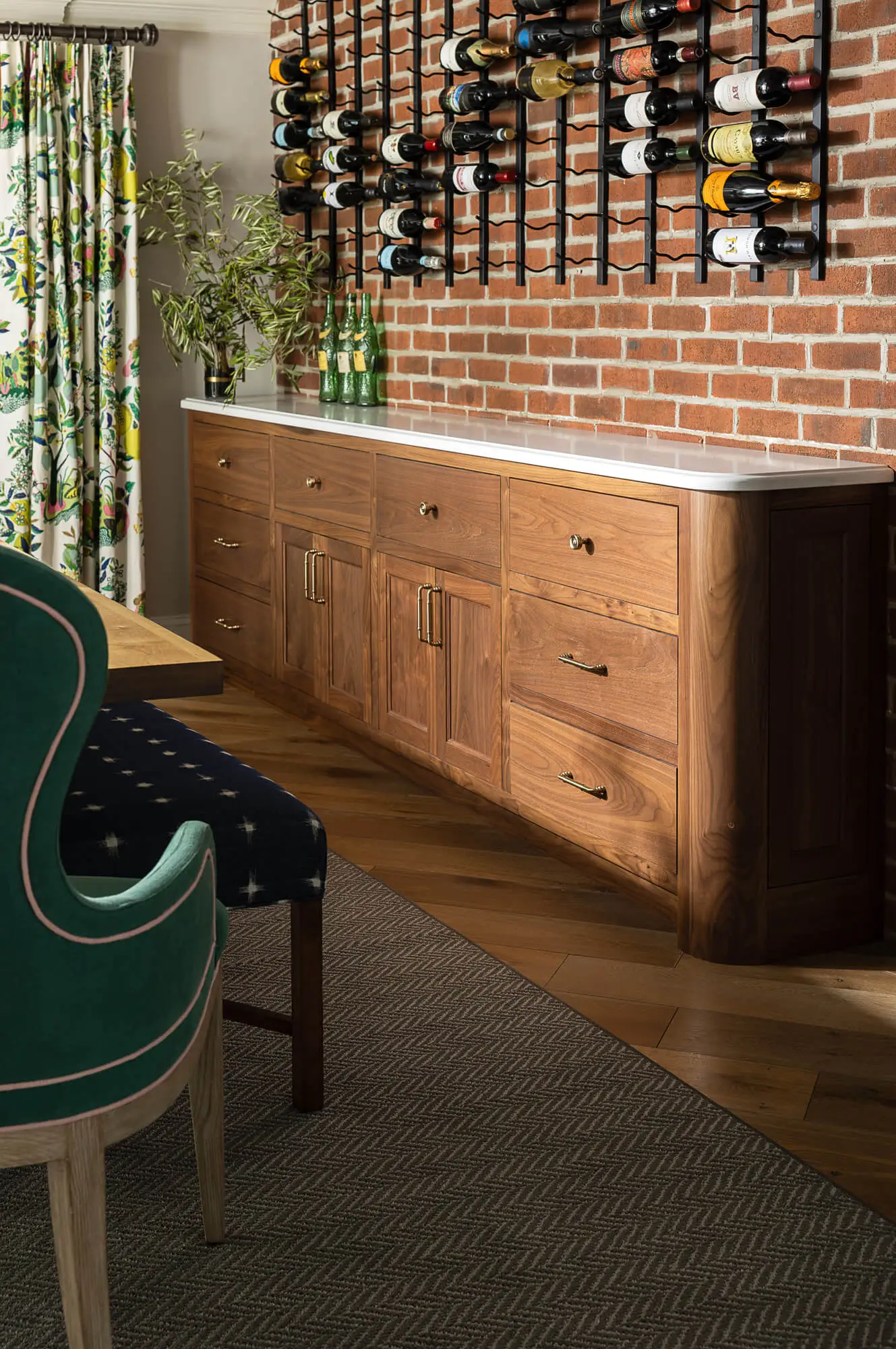 walnut built-in cabinet lining a brick wall