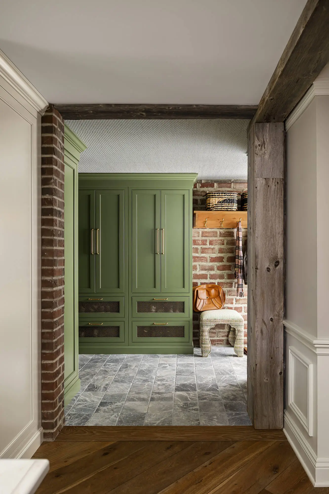 green painted cabinetry in new mudroom with stone flooring